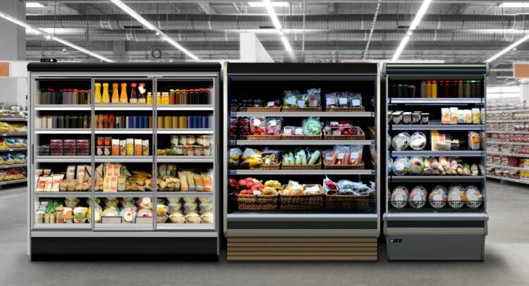 Grocery store refrigerated shelves stocked with fresh produce, juices, and packaged foods.